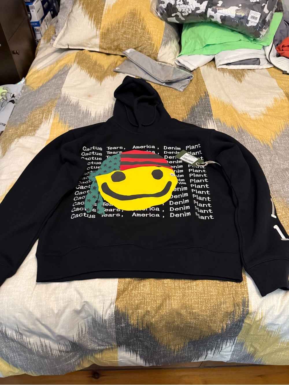 Denim Tears CPFMCactus Plant Flea Market Black Hoodie with Yellow Smiley Graphic